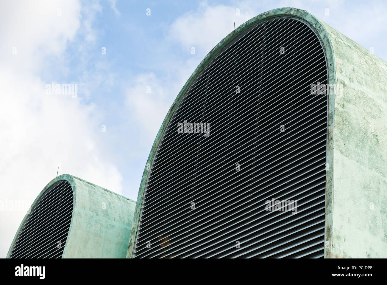 Industrial building fragment, huge green arches with ventilation grilles Stock Photo