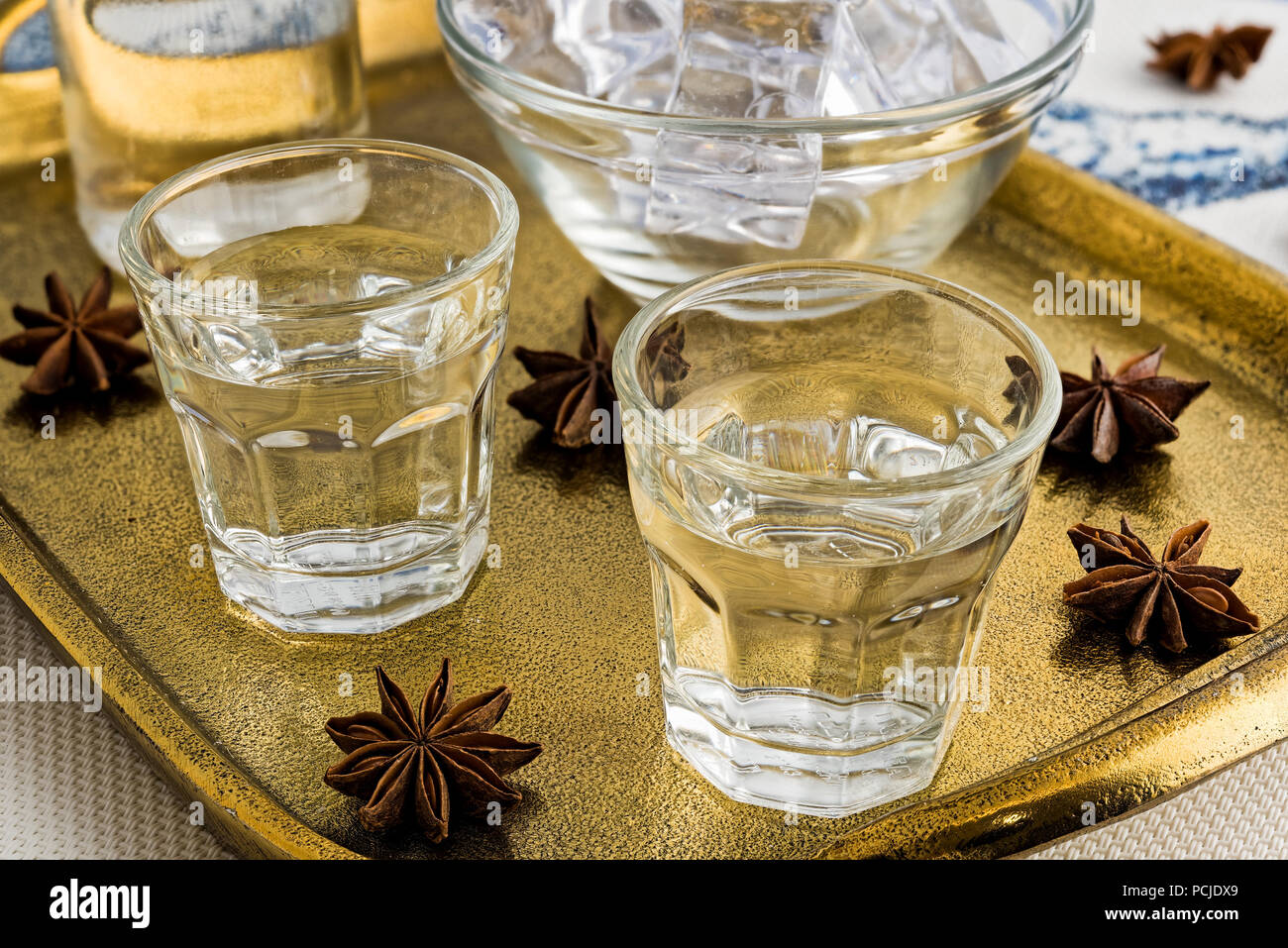 Glasses and bottle of traditional drink Ouzo or Raki on bronze dish ...