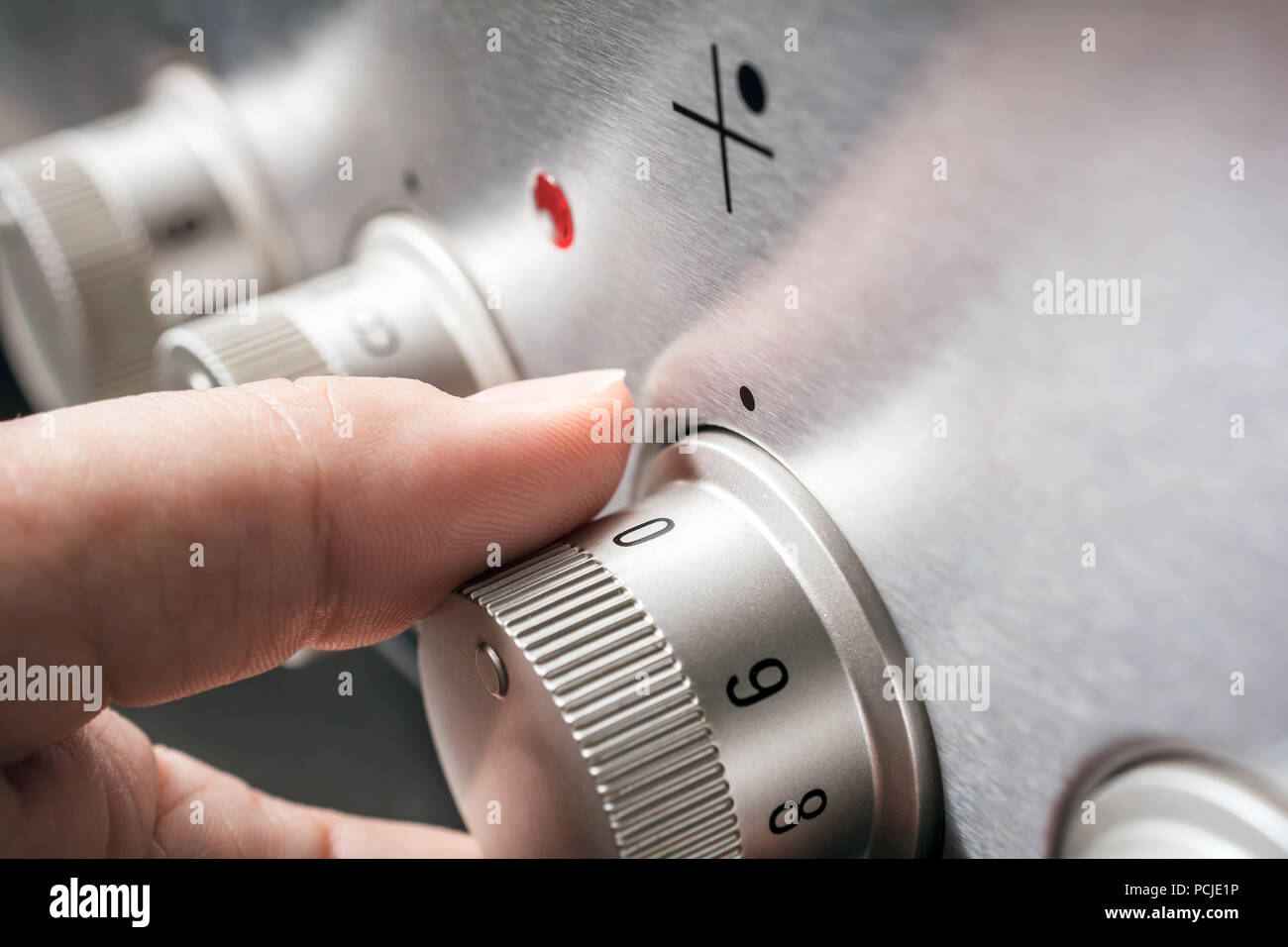 Male Hand On Stove Controls With Heat Level 0 Stock Photo
