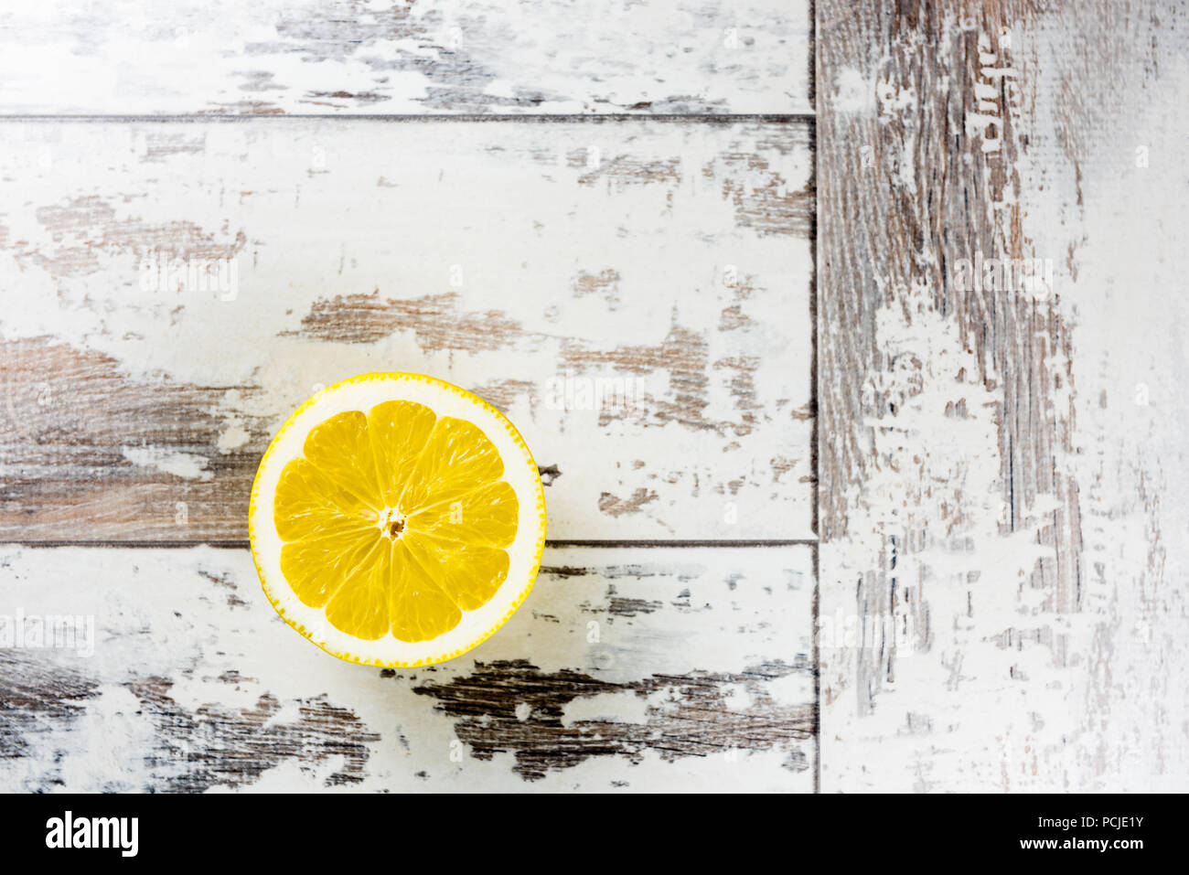 Over head view of half a cut lemon on a rustic wooden table Stock Photo