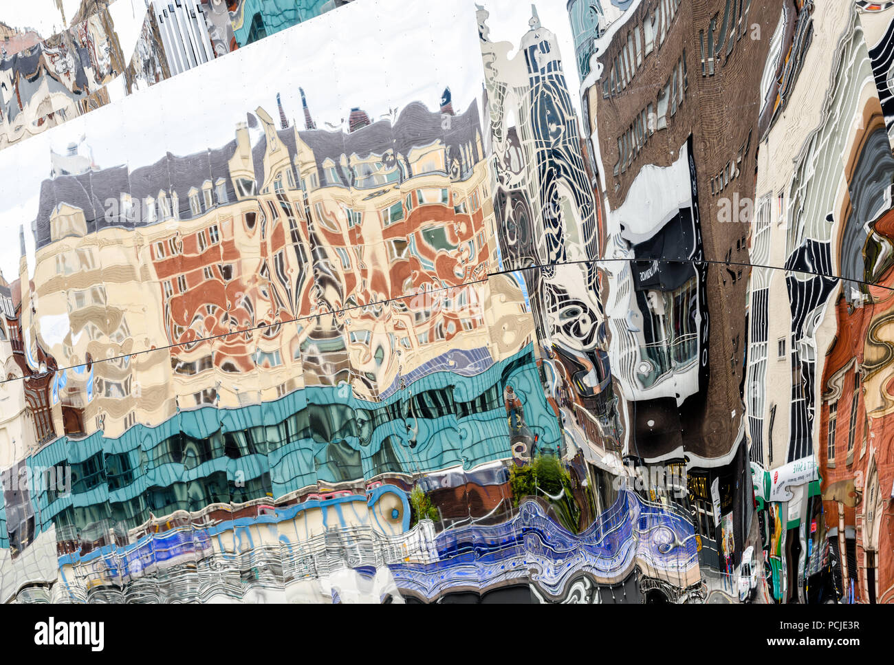 Distorted reflections of buildings in the steel exterior of Birmingham New Street station Stock Photo