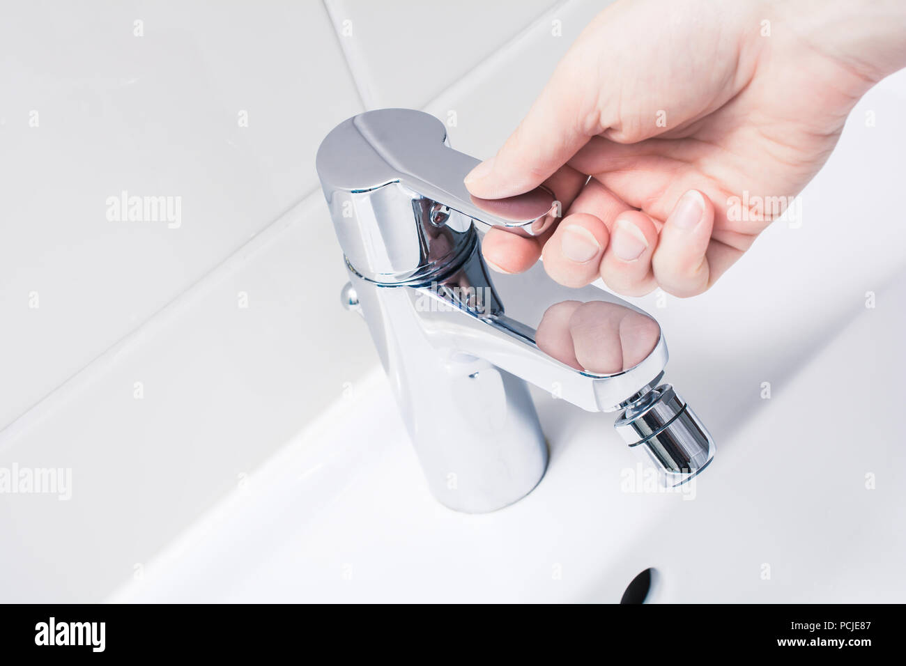 Female Hand On The Handle Of A Chrome Faucet, Ready To Turn On Water Stock Photo Alamy