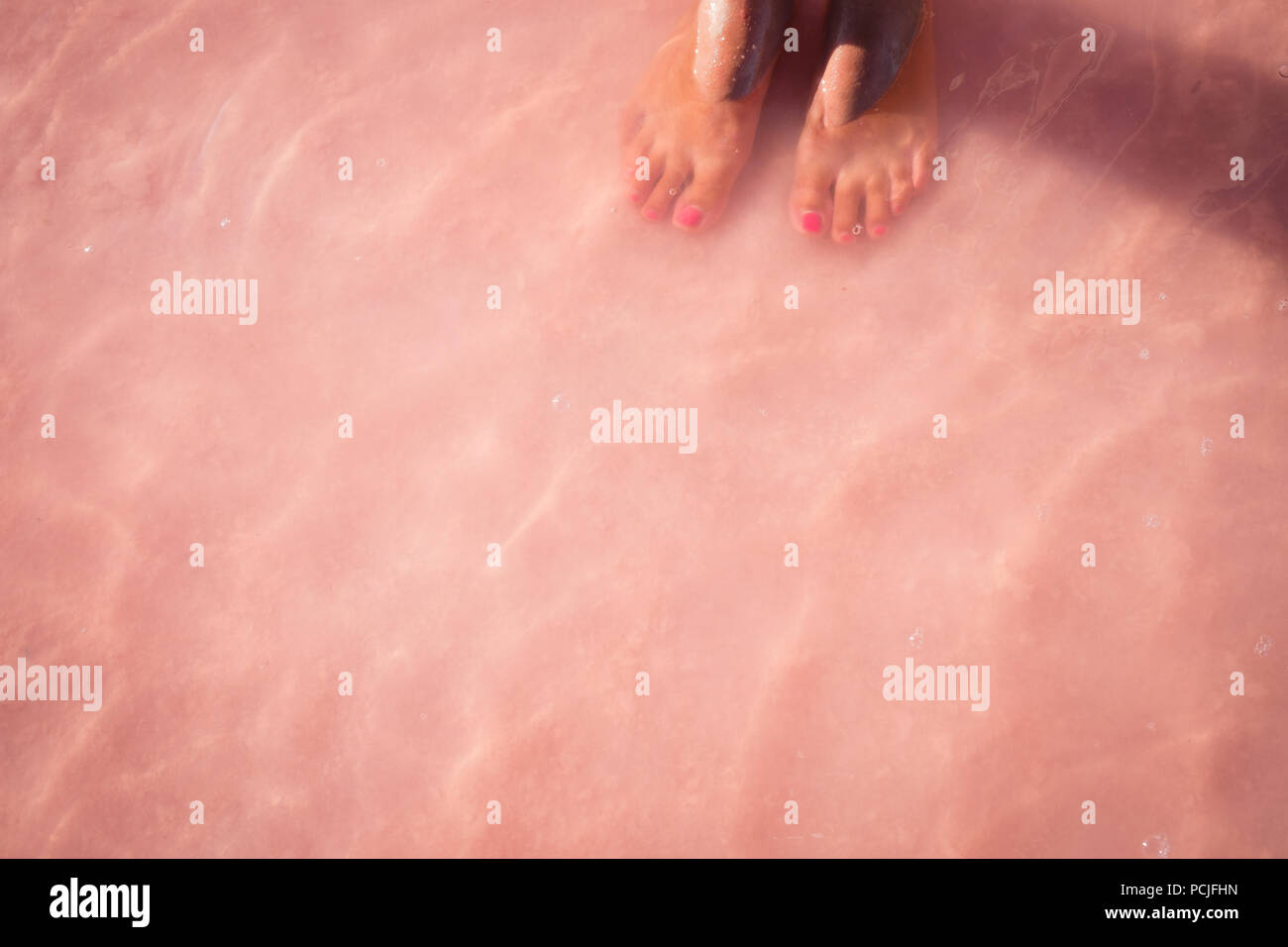 Closeup of a girl's feet in shallow water in ocean, Australia Stock