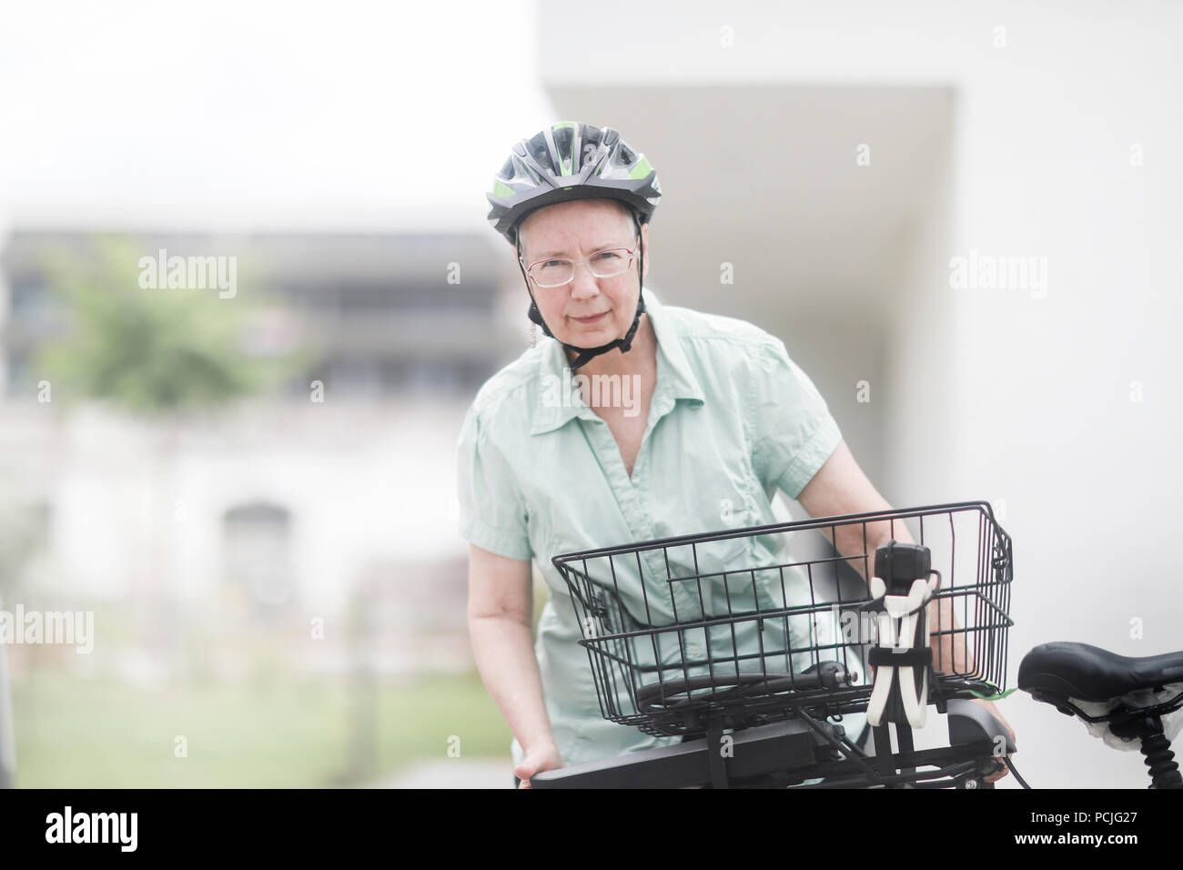 Woman replacing the battery on her e-bike Stock Photo