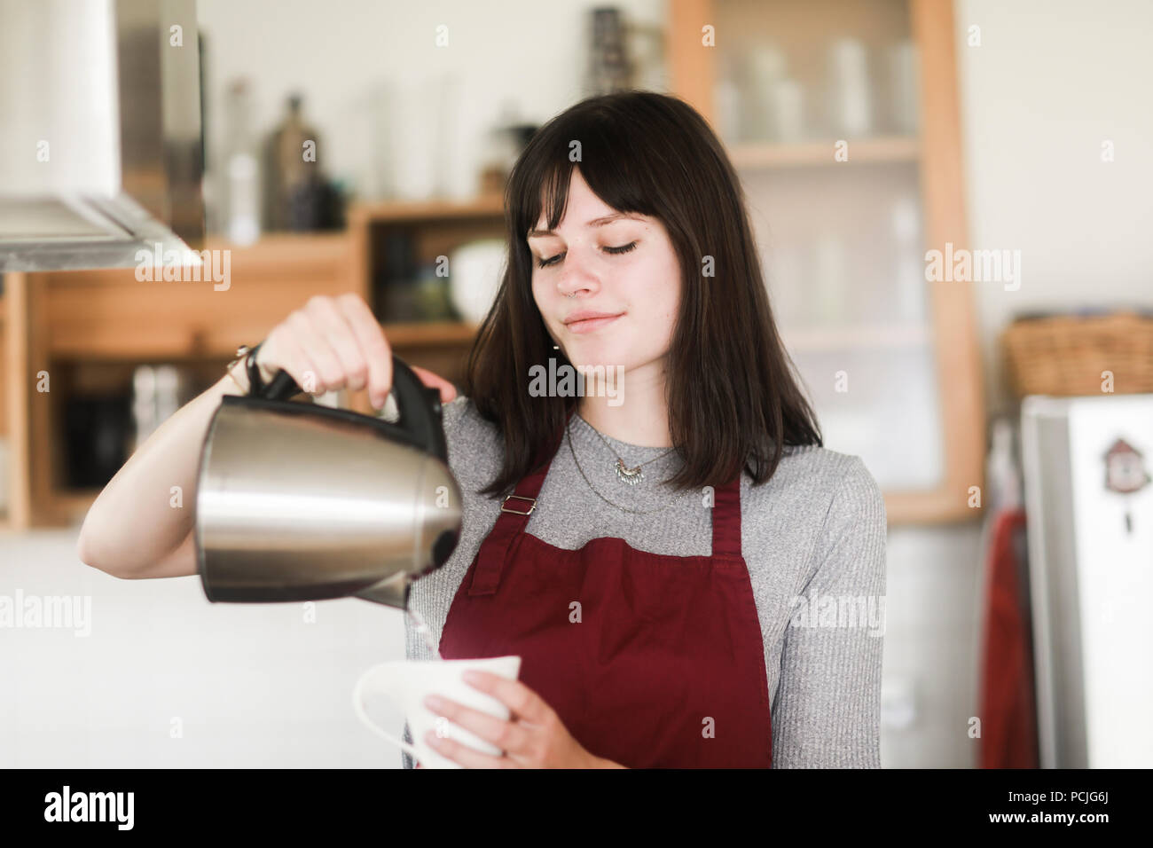 Woman pouring boiling water into a cup Stock Photo Alamy