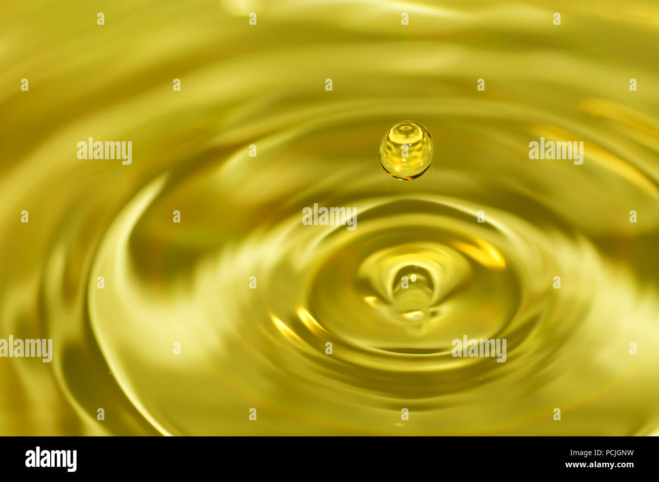 Golden water droplet splashing in water Stock Photo
