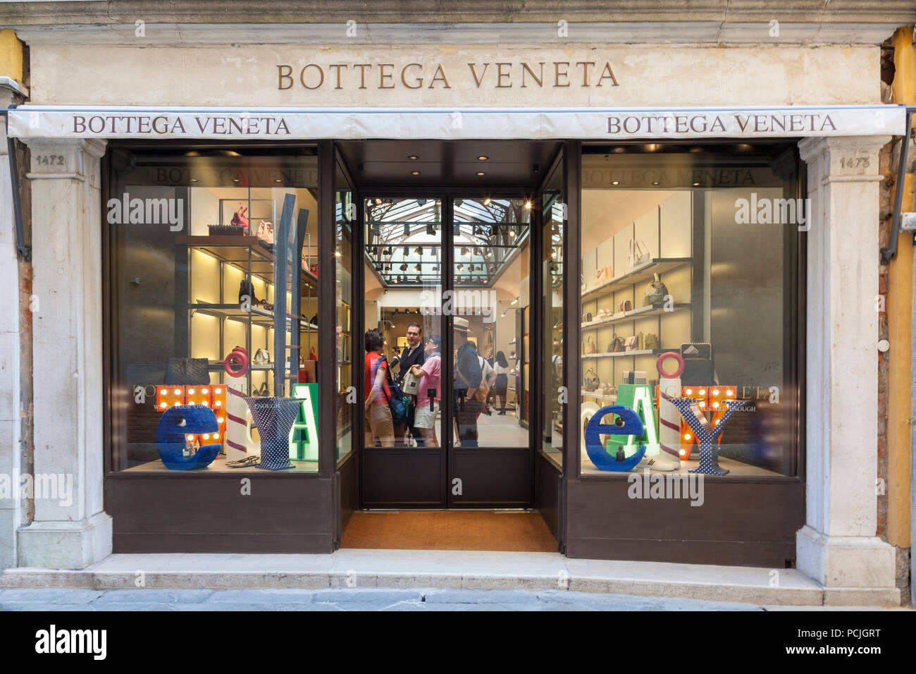 Bottega Veneta fashion store, San Marco, Venice, Veneto, Italy. Front window, entrance, signage, sign, fashion accessories, customers, people, shop, s Stock Photo