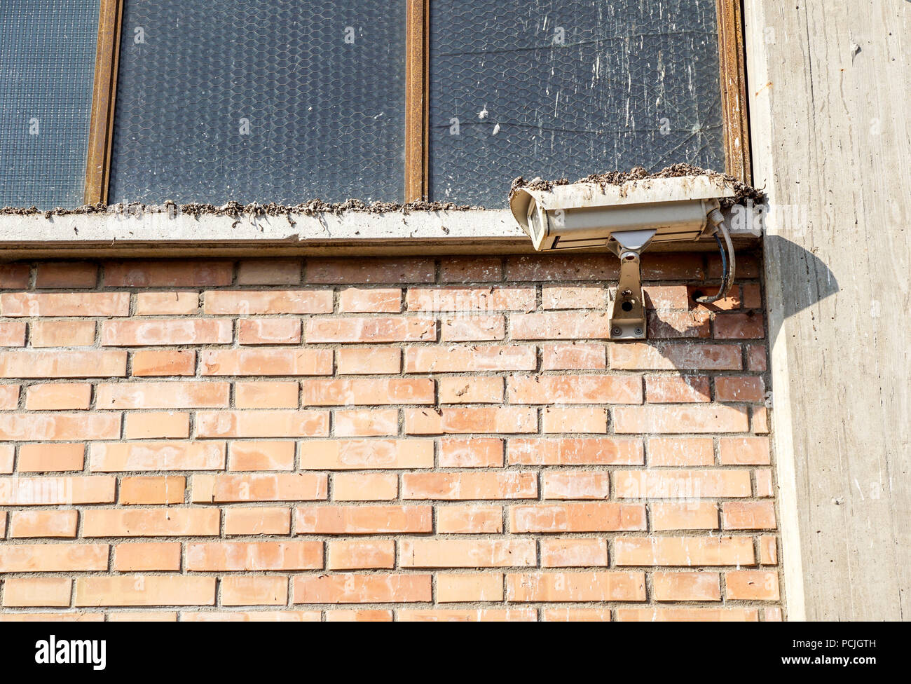 Old dirty Security camera on industrial building Stock Photo