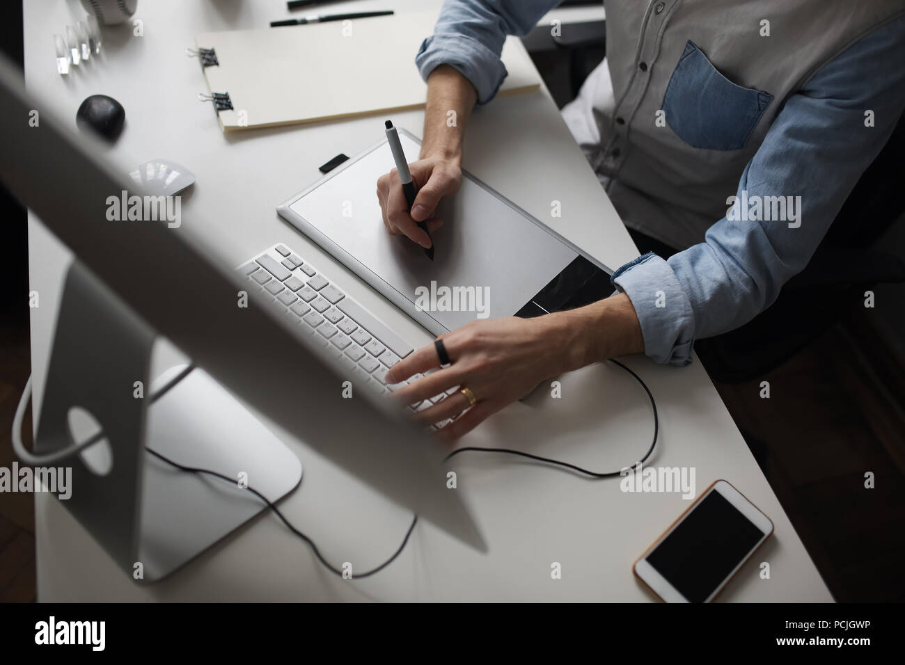 Young male designer using graphics tablet while working with com Stock Photo