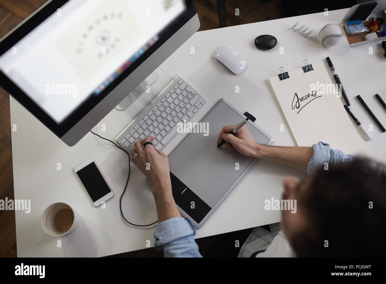Young male designer using graphics tablet while working with com Stock Photo