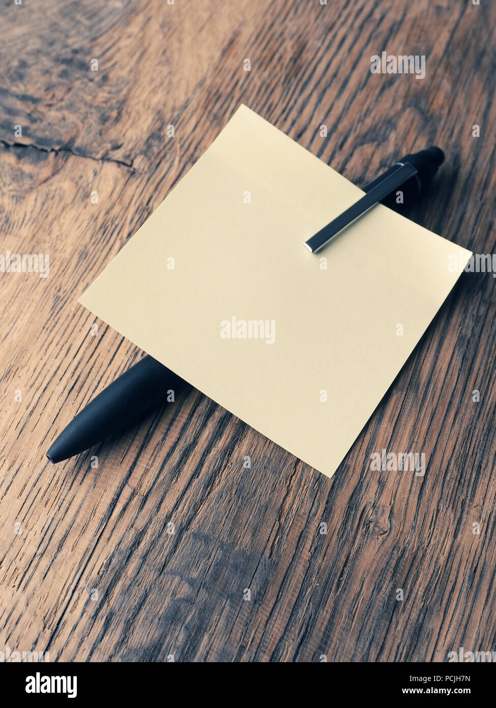 Sticky note with a pen on a table, close up shot, high angle view Stock Photo