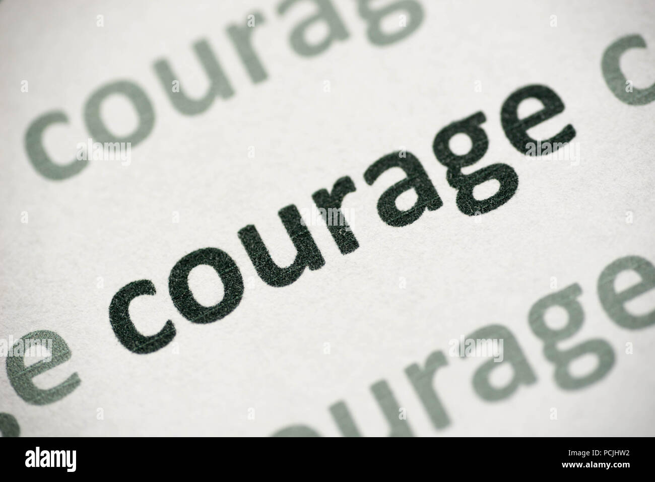word courage printed on white paper macro Stock Photo
