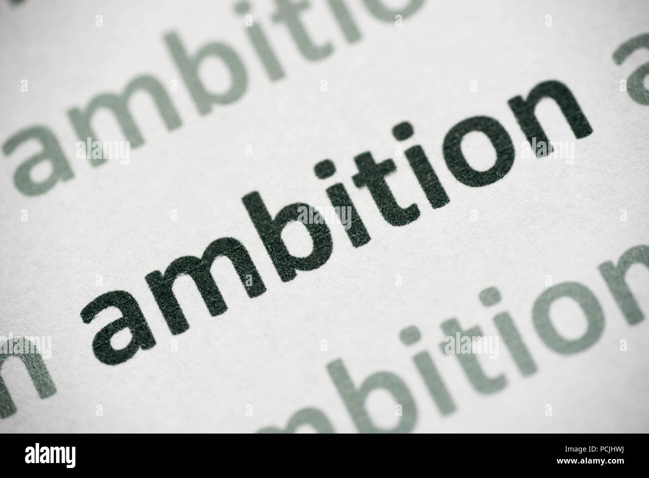 word ambition printed on white paper macro Stock Photo