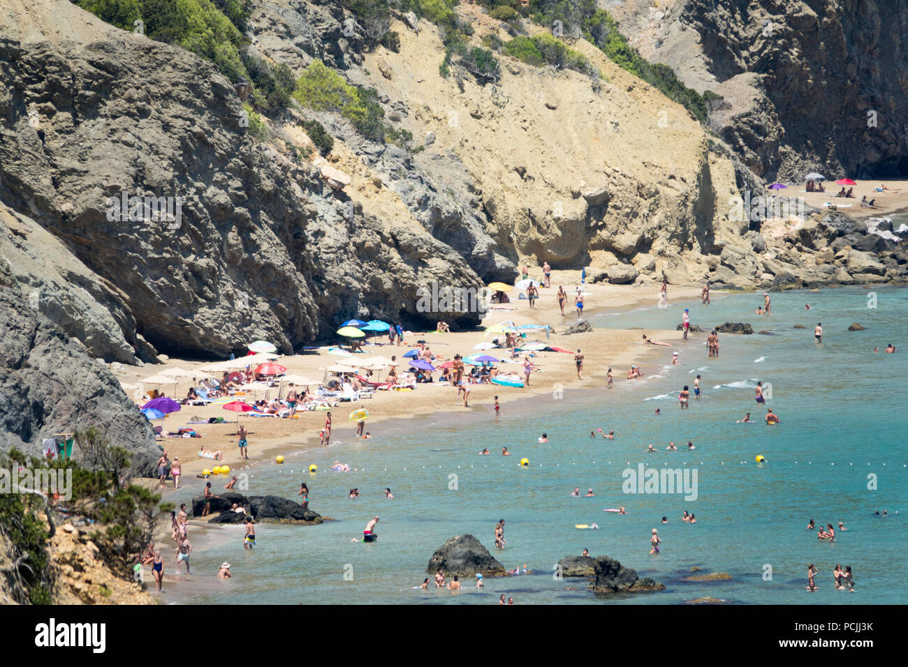 Visitors and holidaymakers on Agua Blanca beach  in Ibiza, Spain. Stock Photo