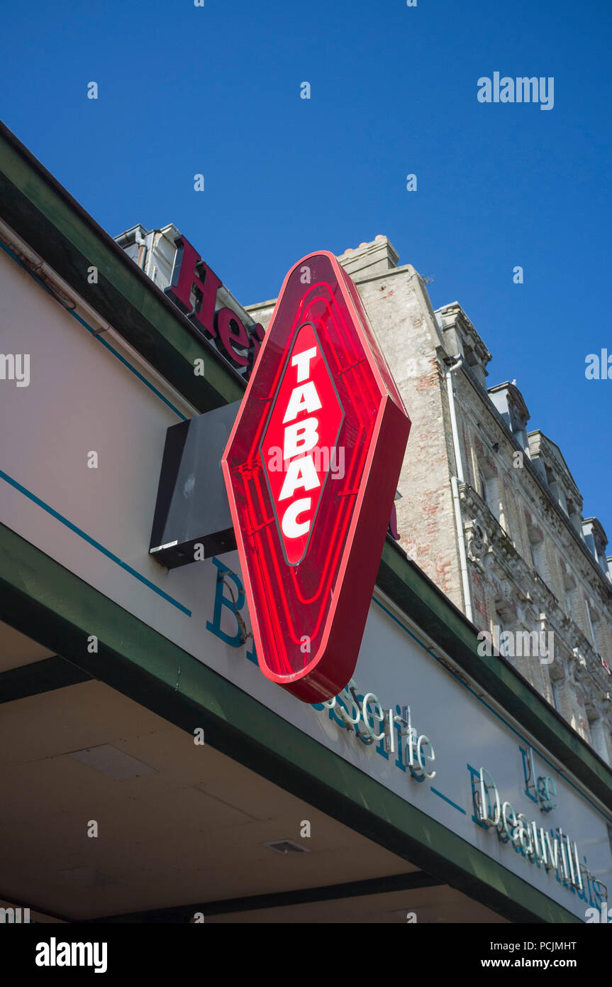 Iconic red 'Tabac' or tobacconist's sign opposite the station in Deauville, France Stock Photo