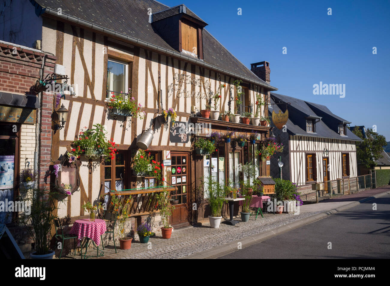 Traditional half-timbered hotel in the village of Marais Vernier, Normandy, France, decorated with pots and hanging baskets of geraniums Stock Photo