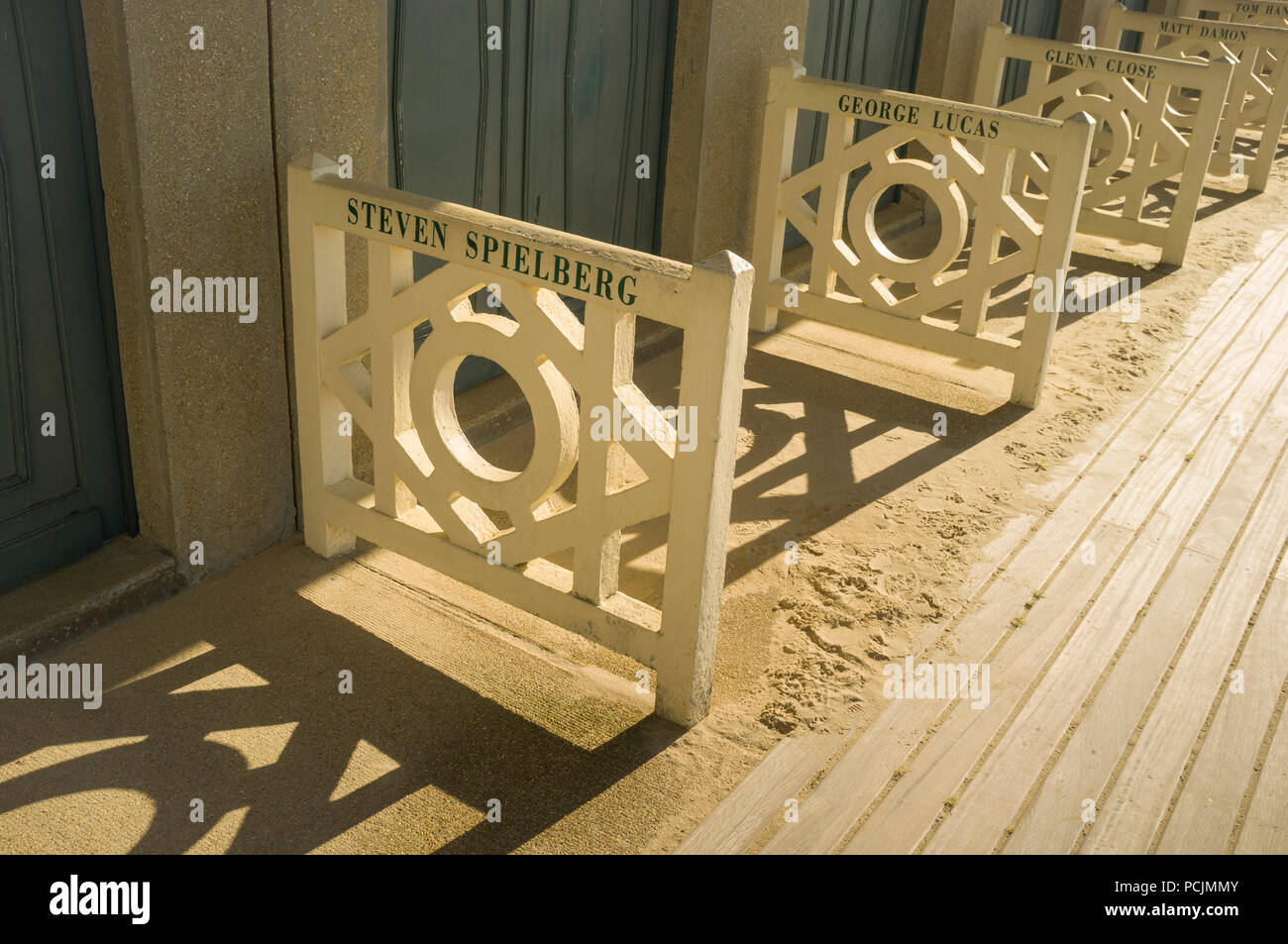 Iconic changing rooms beach cabins named after film stars on the Les Planches boardwalk in Deauville, Normandy, France. Stock Photo