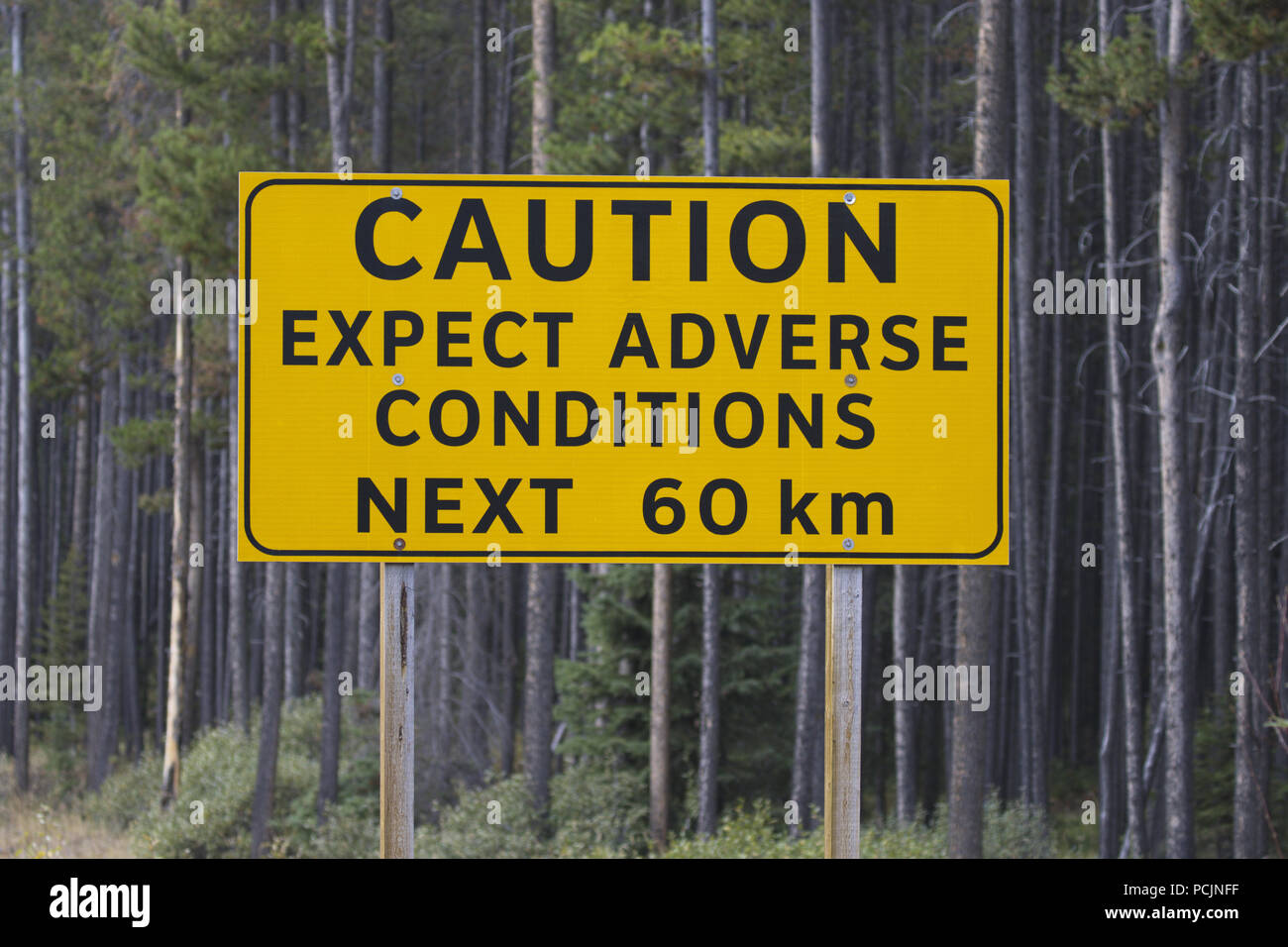 Caution sign on Spray Lakes Road warns about possible adverse conditions on back country roads in Alberta near Banff and Canmore. Stock Photo