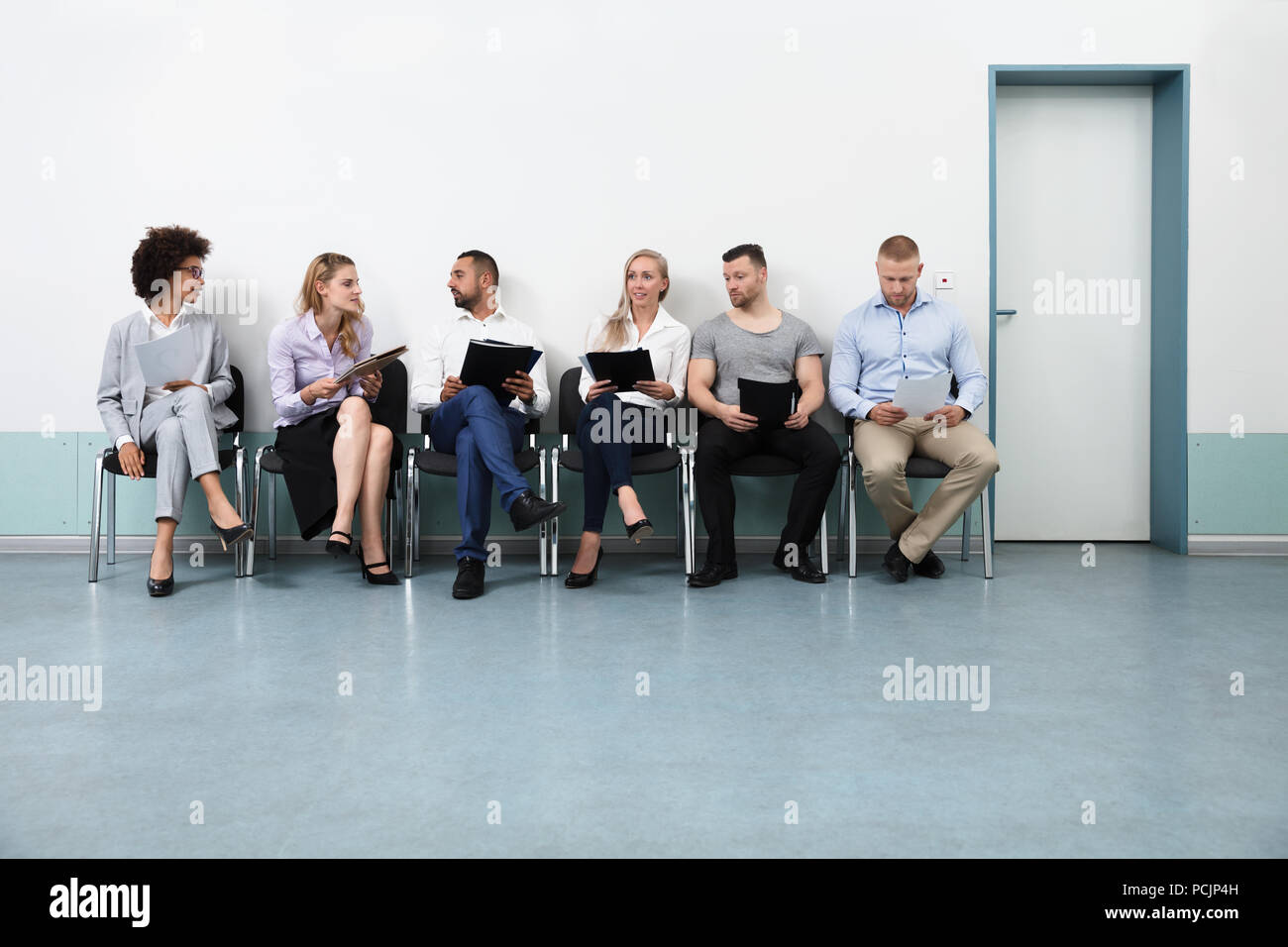 Candidates Sitting On Chair Waiting For An Interview Stock Photo