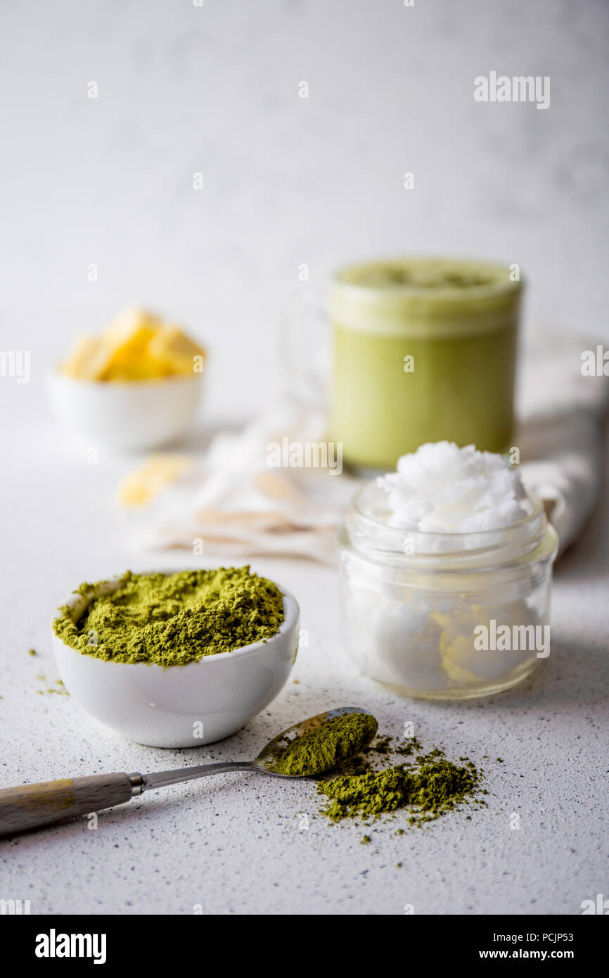 BULLETPROOF MATCHA. Ketogenic keto diet hot drink. Tea matcha blended with coconut oil and butter. Cup of bulletproof matcha and ingredients on white background Stock Photo