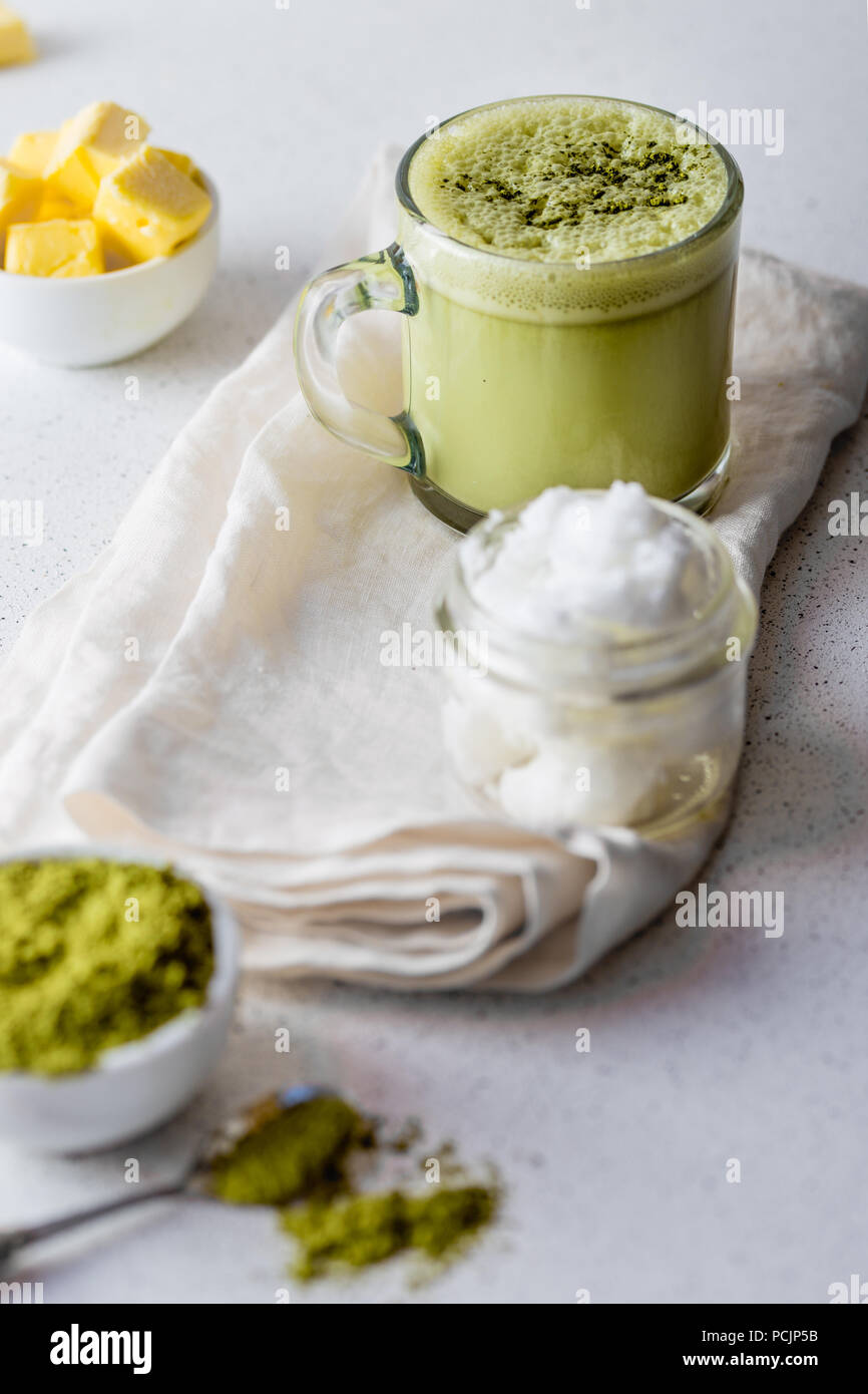 BULLETPROOF MATCHA. Ketogenic keto diet hot drink. Tea matcha blended with coconut oil and butter. Cup of bulletproof matcha and ingredients on white background Stock Photo