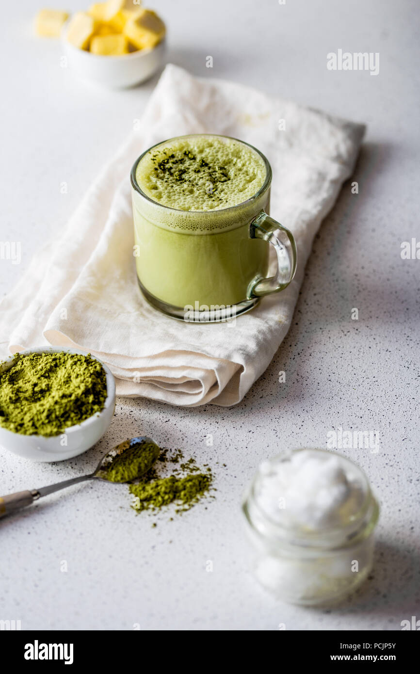 BULLETPROOF MATCHA. Ketogenic keto diet hot drink. Tea matcha blended with coconut oil and butter. Cup of bulletproof matcha and ingredients on white background Stock Photo