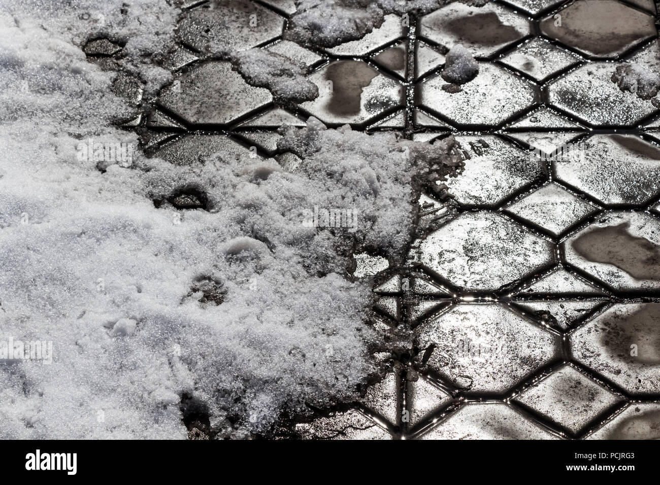 Spring thaw in the area covered with paving tiles. Stock Photo