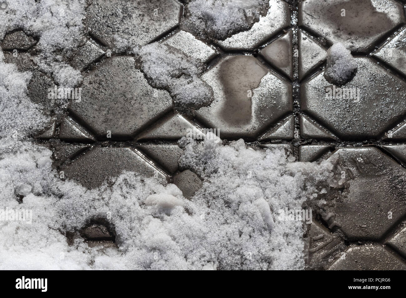 Spring thaw in the area covered with paving tiles. Stock Photo