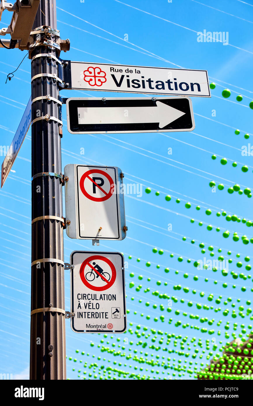 Rue de la visitation, no parking and no bicycle riding  street signs and the green balls of gay village in Montreal, Canada Stock Photo