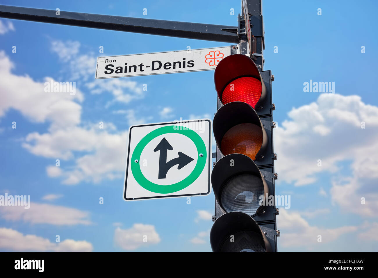 Saint Denis street sign attached to a traffic light signaling red in Montreal Quebec Canada Stock Photo