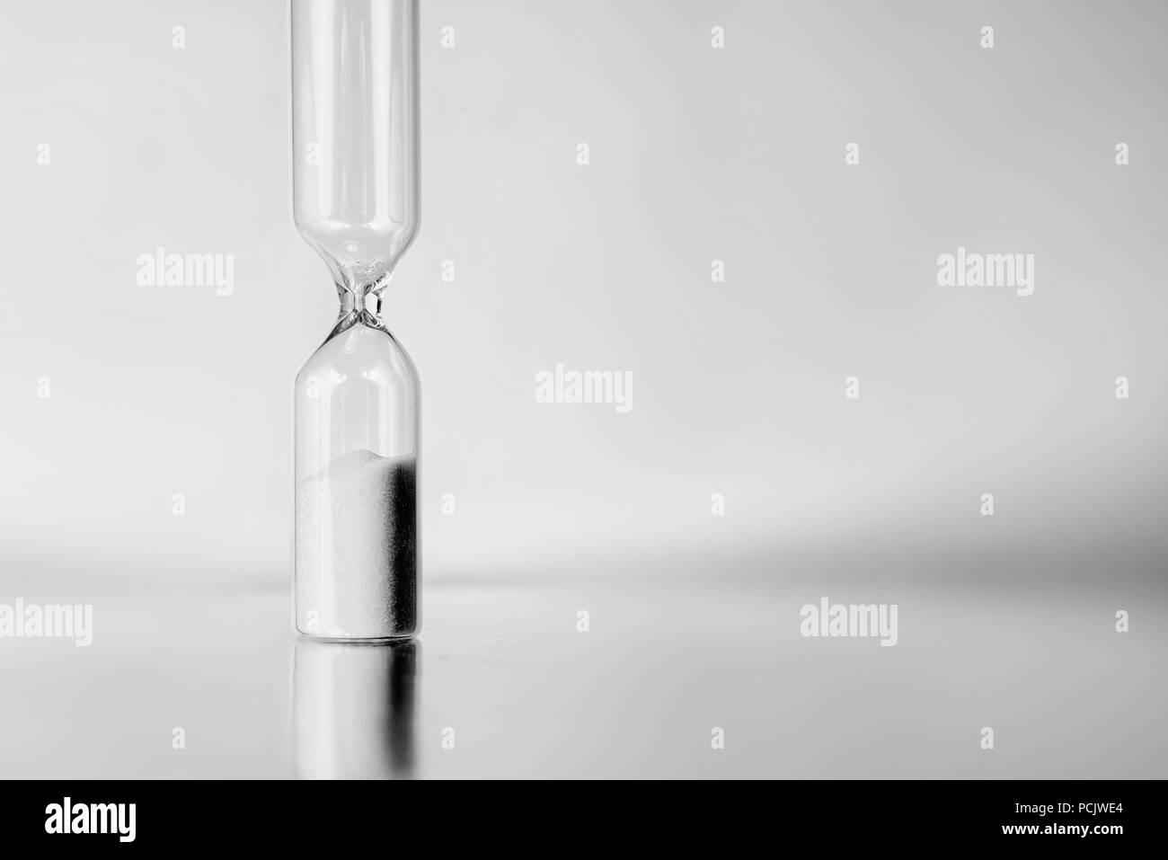 Time is over. Empty hourglass. Black and white photo with space for text. Stock Photo