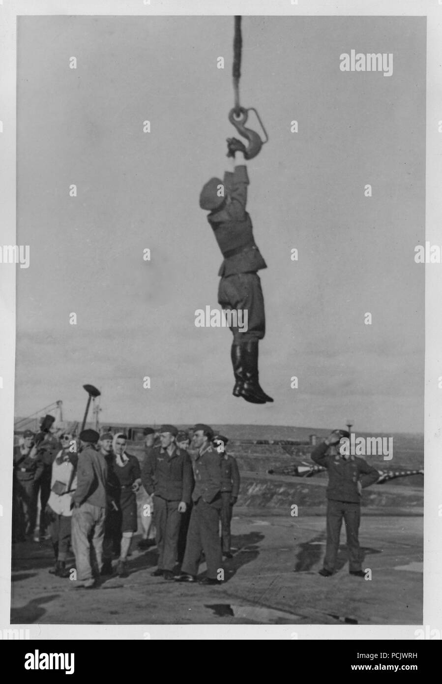 Image from the photo album of Oberleutnant Wilhelm Gaul - An officer of 2. Staffel, Küstenfliegergruppe 906 is hoisted by the crane used to lift the unit's Heinkel He 115 floatplanes into the water, at Brest in 1941 or 1942. Stock Photo