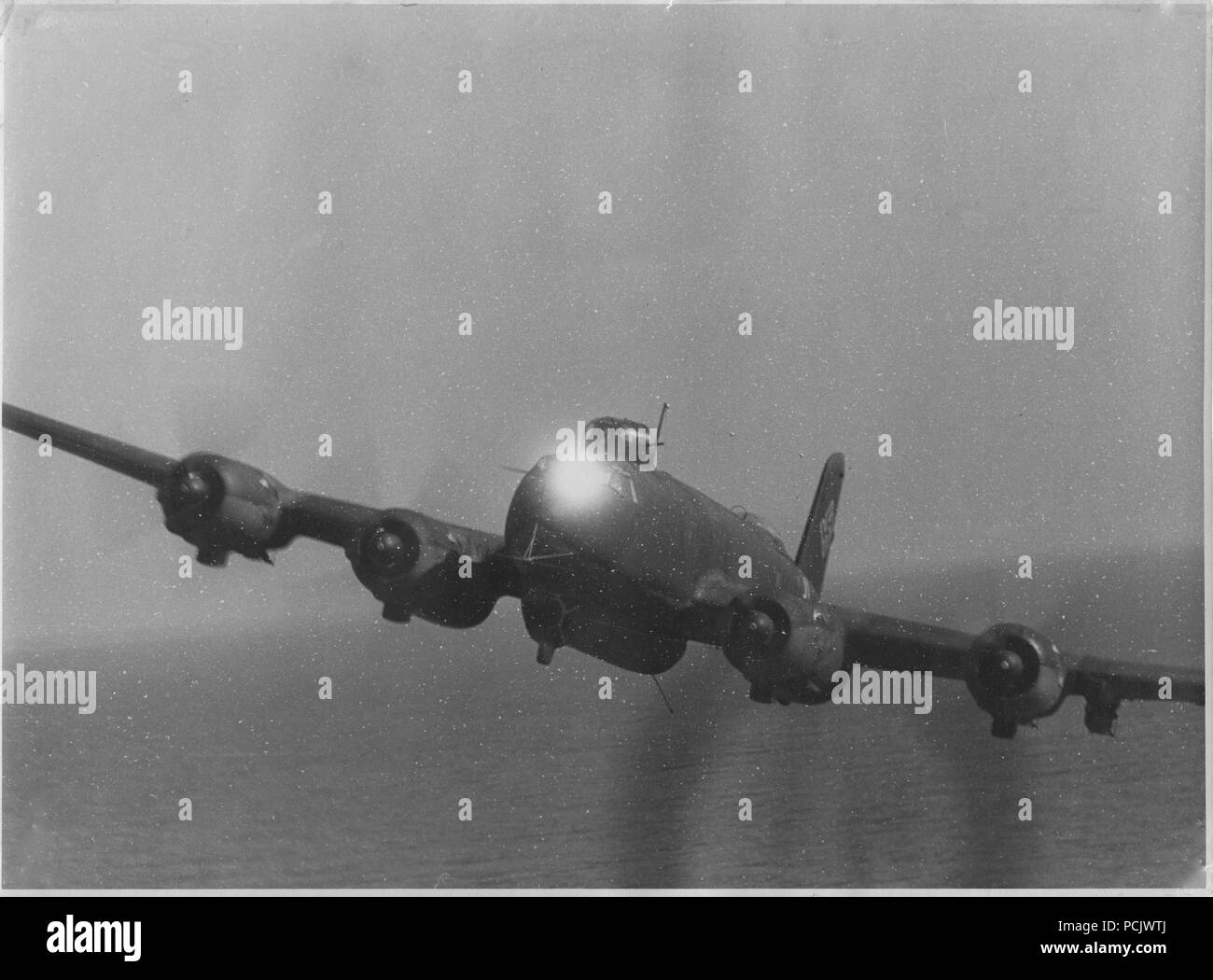 Image from the photo album of Hauptmann Wilhelm Gaul - Taken from the dorsal gun position of another FW 200, a Focke Wulf FW 200C-8 Condor  of III./KG40, flying out of Bordeaux Mérignac, catches the reflection of the sun on its forward gun turret as it forms up on its sister aircraft. Stock Photo