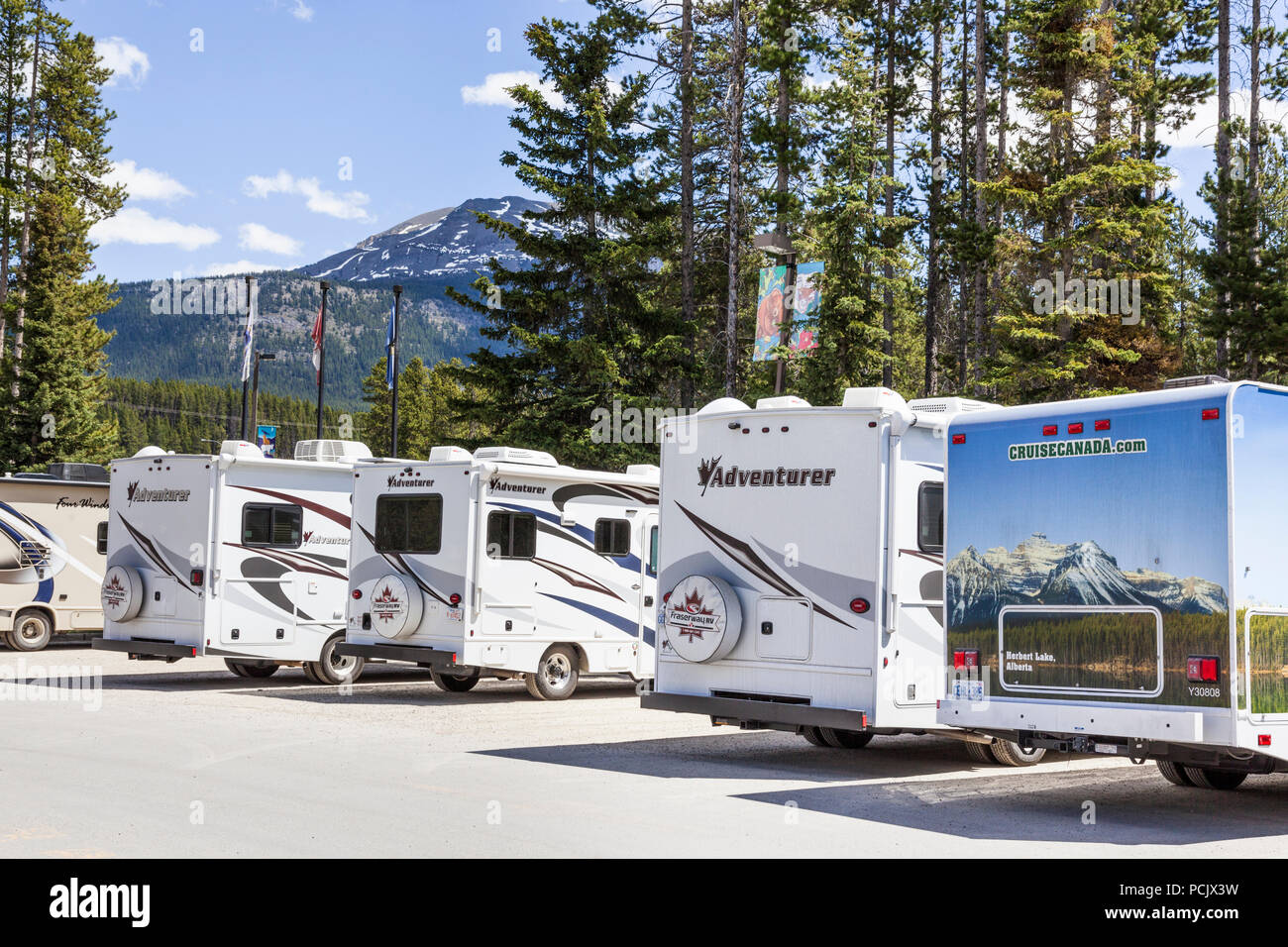 Motor homes in a car park in the Rocky Mountains at the town of Lake Louise, Alberta, Canada Stock Photo