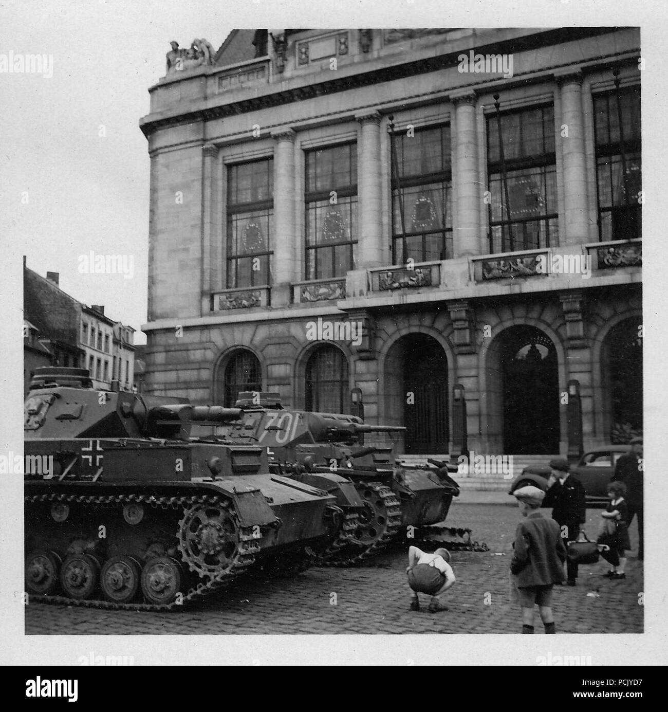 Image from a photo album relating to II. Gruppe, Jagdgeschwader 3: A Panzer III with a broken track sits behind a Panzer IV in a French town in summer 1940 Stock Photo