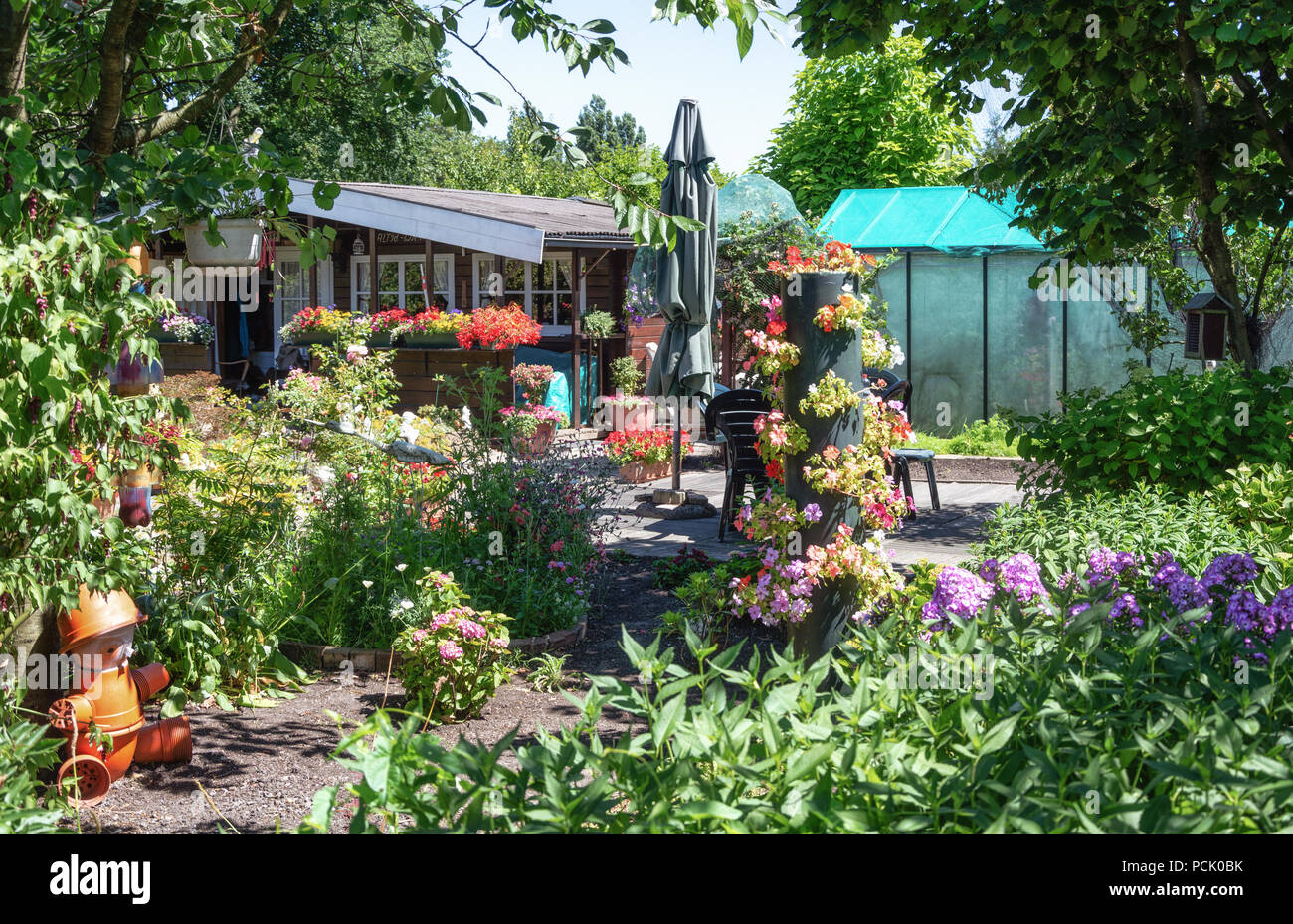 Zaandam, The Netherlands, July 2, 2018: Garden shed and greenhouse surrounded by a beautiful decorative garden in The Netherlands Stock Photo