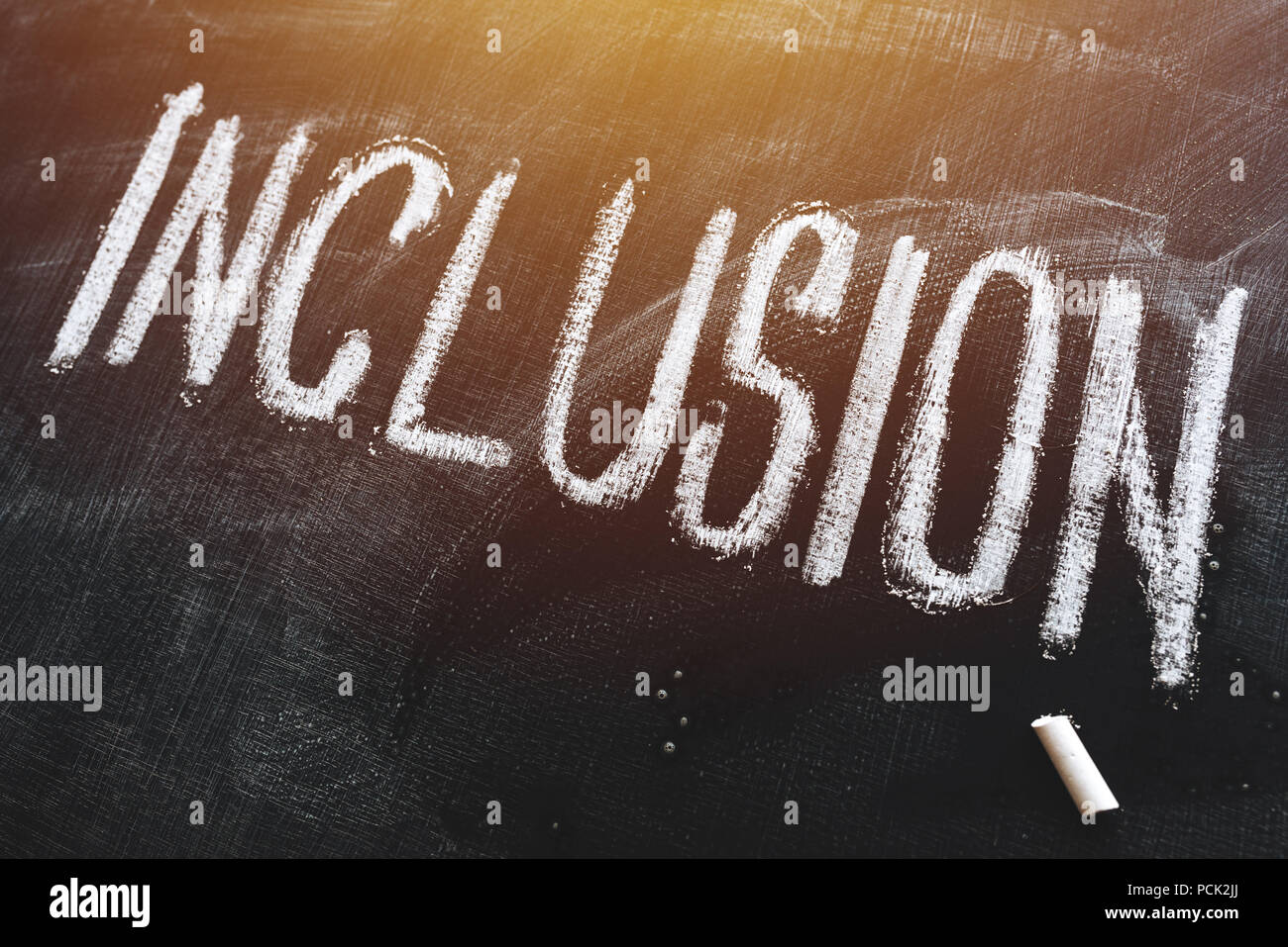 Word Inclusion on school blackboard written with chalk Stock Photo