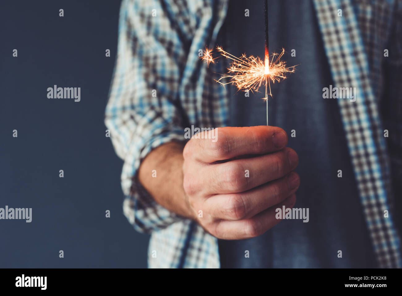 Man holding stick sparkler, close up of hand Stock Photo