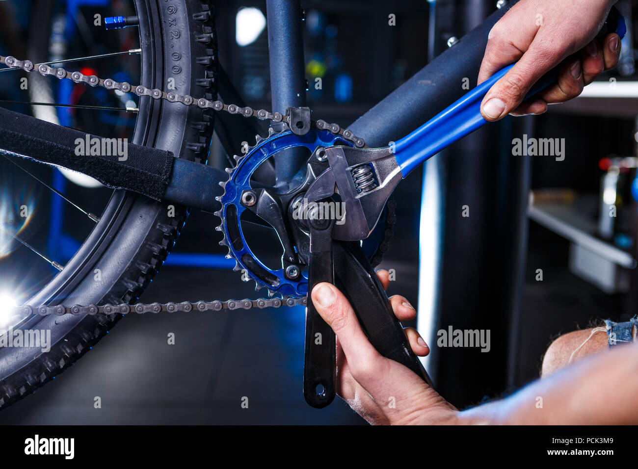 A close-up of a male bicycle mechanic's hand in the workshop uses a  screwdriver tool to adjust and repair the bicycle crank assembly, the front  bike s Stock Photo - Alamy