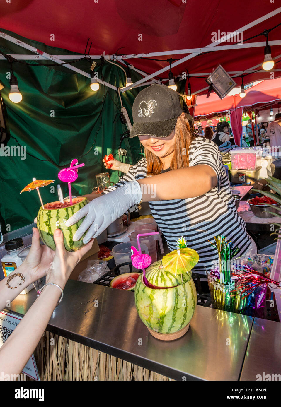 Drink in a real fruit cup at Richmond  Night Market, Richmond, BC, Canada. The market is open weekends and holiday Mondays during summer. Stock Photo