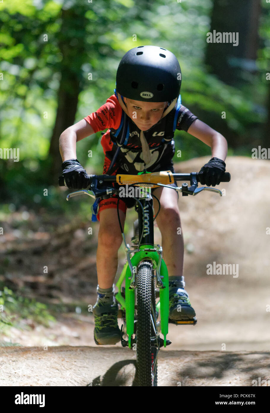 A young boy (6 yr old) riding his bike looking straight at the camera, Kingdom Trails, East Burke, Vermont, USA Stock Photo