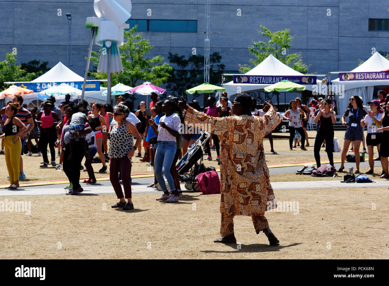 An African man in traditional african clothes dancing at the Montreal Nuits D'Afrique festival Stock Photo