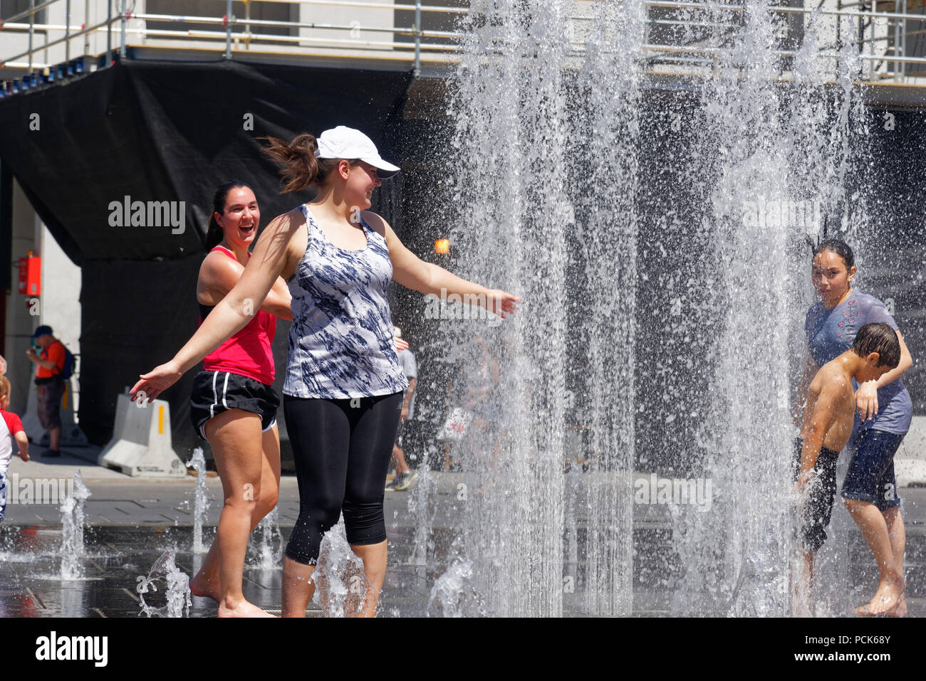 People keeping cool in the water fountains in Montreal in the 2018 heatwave Stock Photo