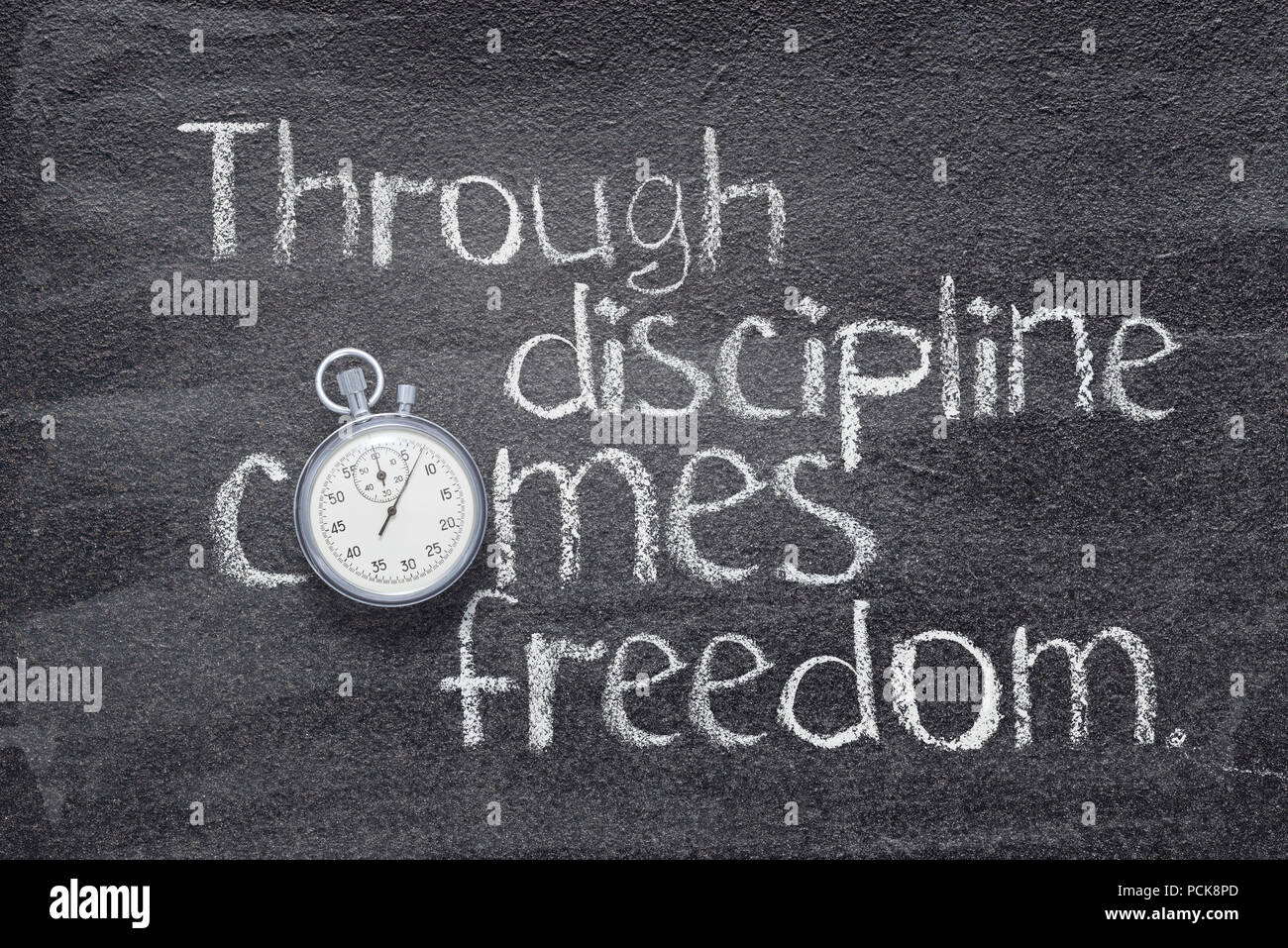 through discipline comes freedom quote handwritten on chalkboard with vintage precise stopwatch used instead of O Stock Photo