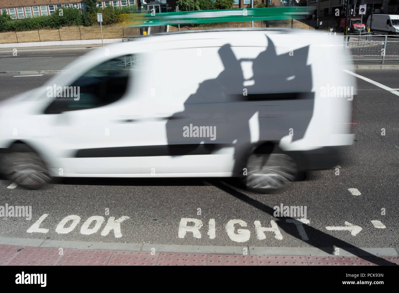 the shadow of traffic lights seen on a white van passing a look right road marking, isleworth, middlesex, england Stock Photo