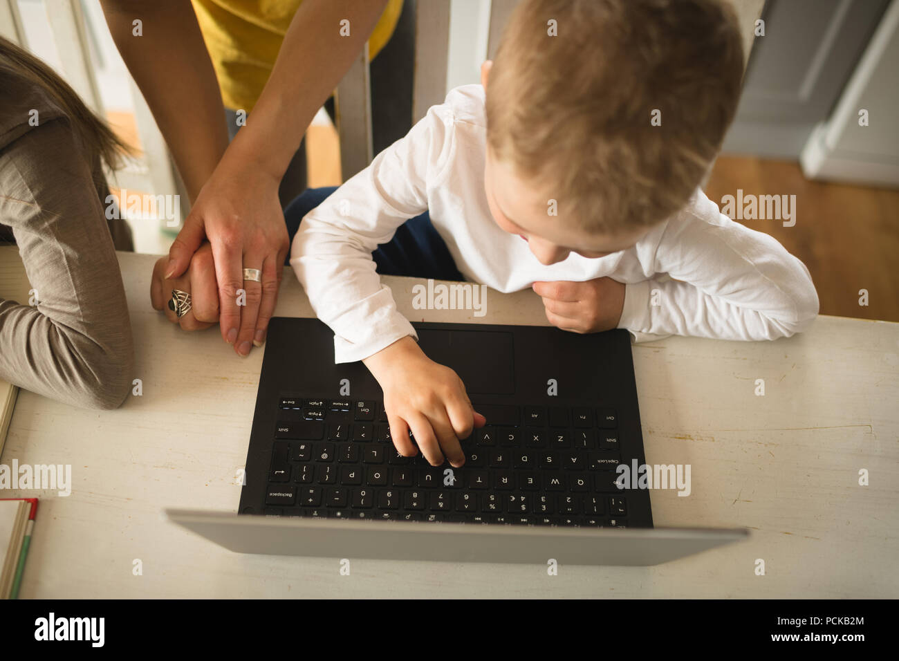 Mother teaching son using laptop at home Stock Photo