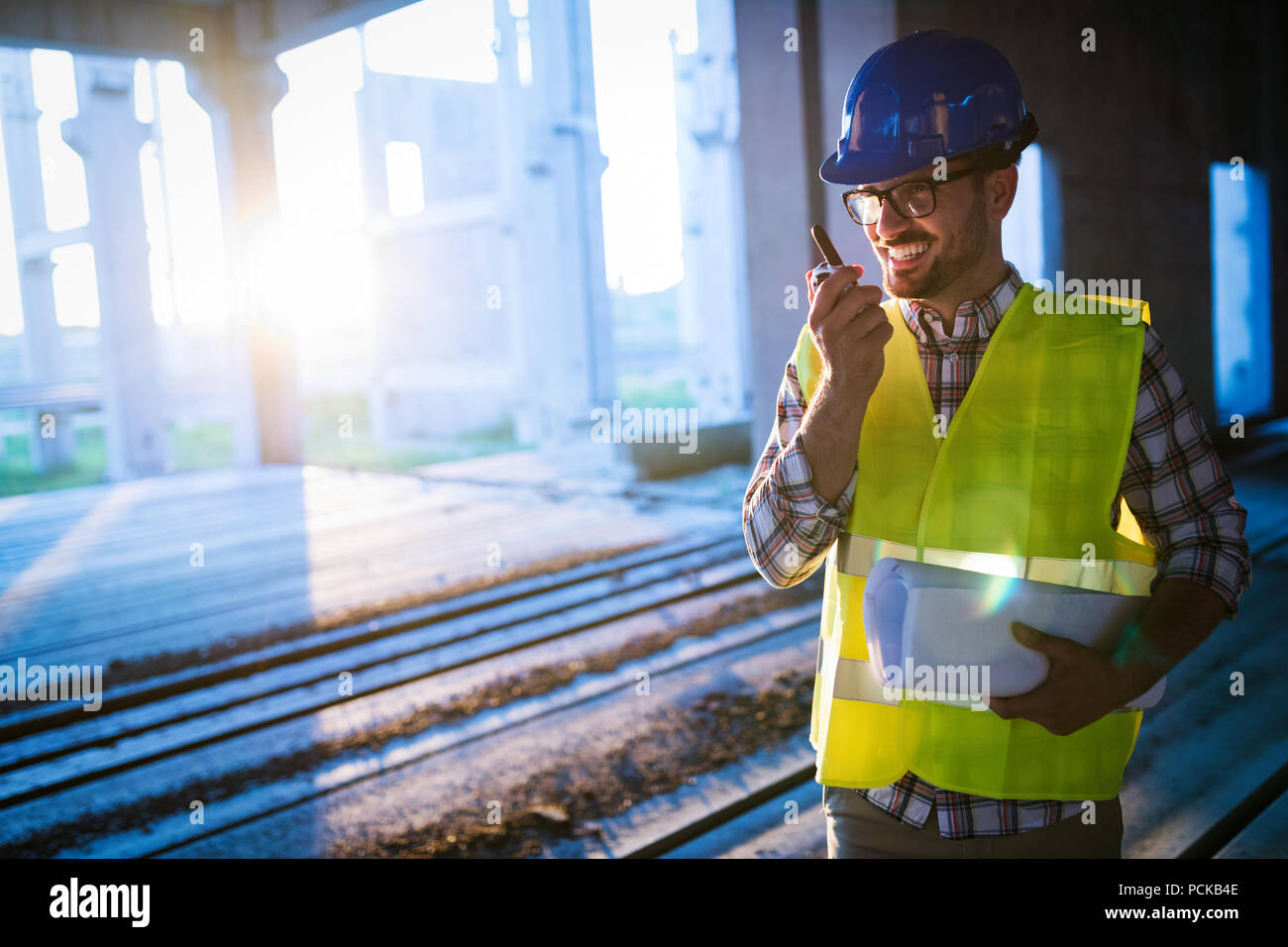Male architect communicating on walkie-talkie at site Stock Photo