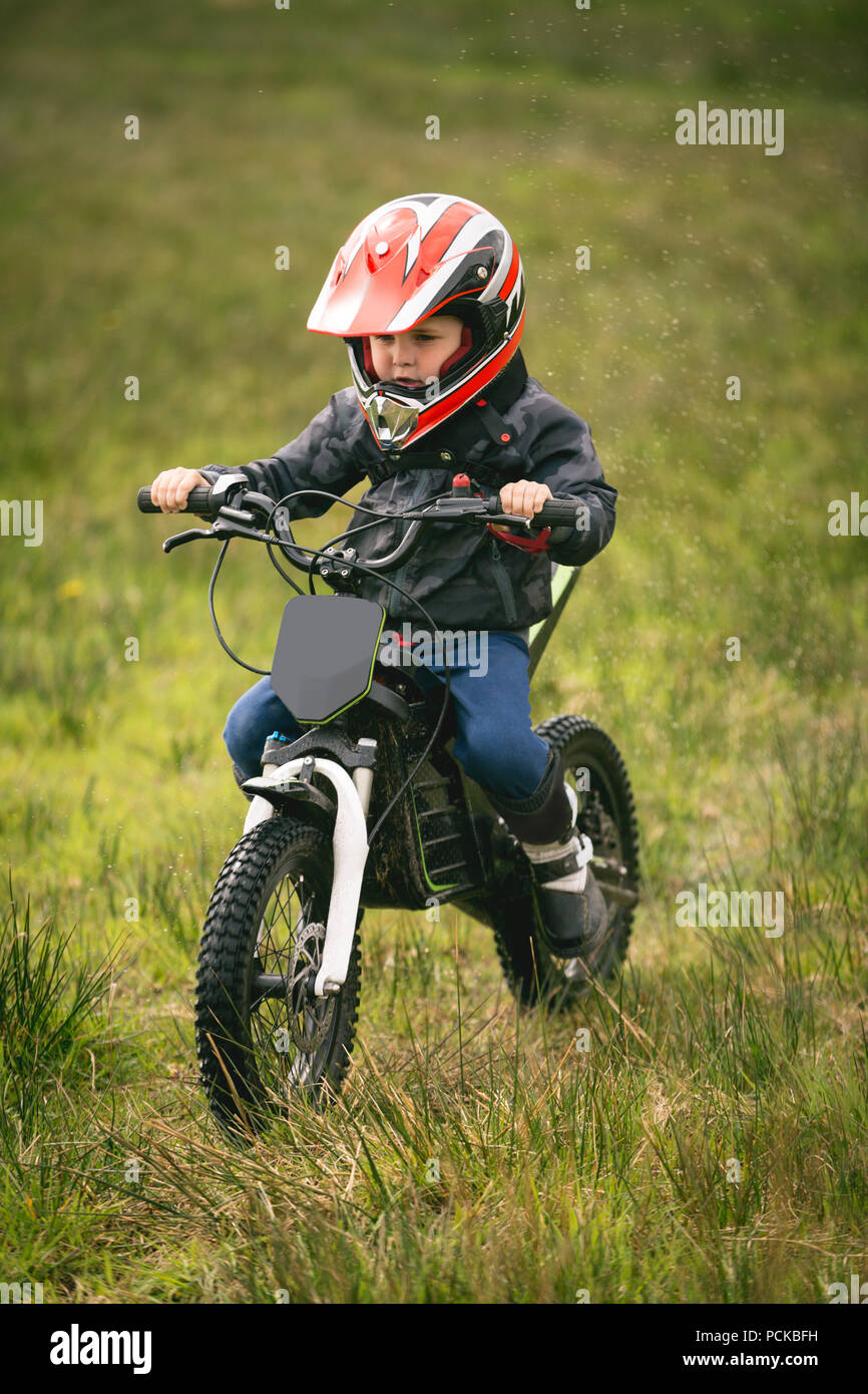 Kid rider riding a bike in garden Stock 
