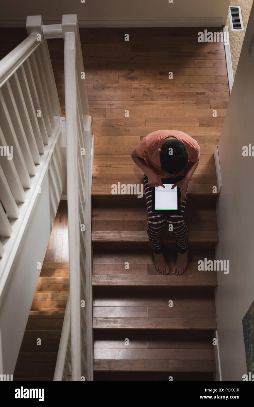 Boy using digital tablet on stairs Stock Photo