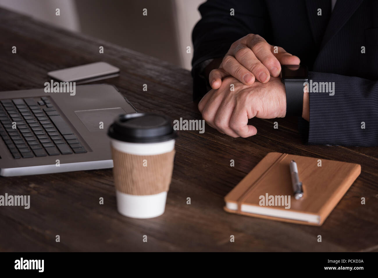Businessman checking smart watch in creative office Stock Photo